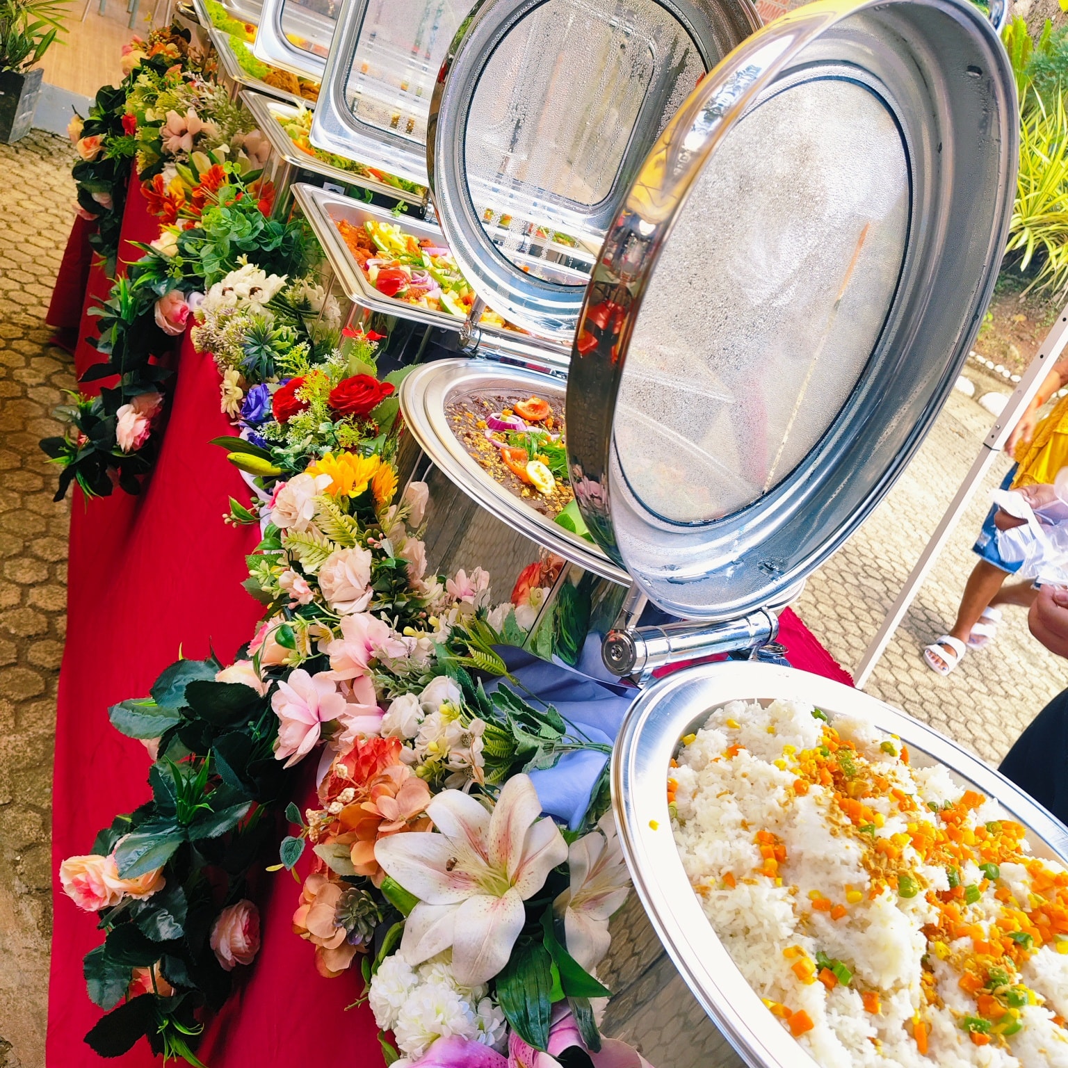 Full buffet setup with chafing dishes and floral garnish